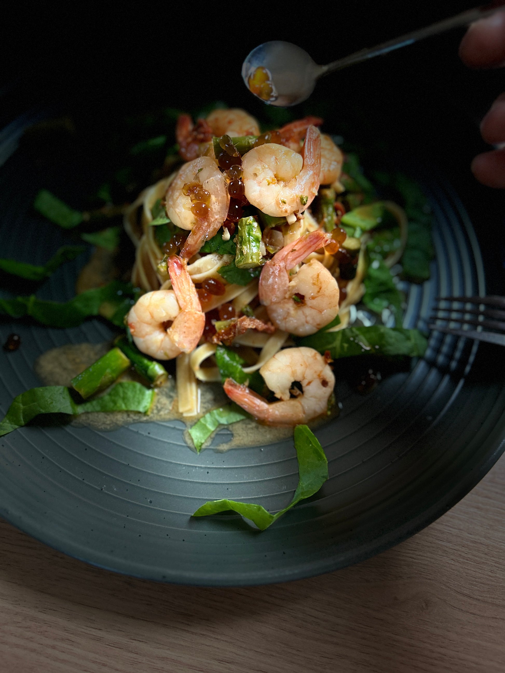Prawn Pasta with 
Premium Pomegranate Pearls - Sticky Balsamic on a grey plate with a dark background
