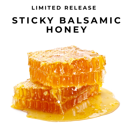 Sticky Balsamic Honey show honeycomb with honey dripping off it on a white background