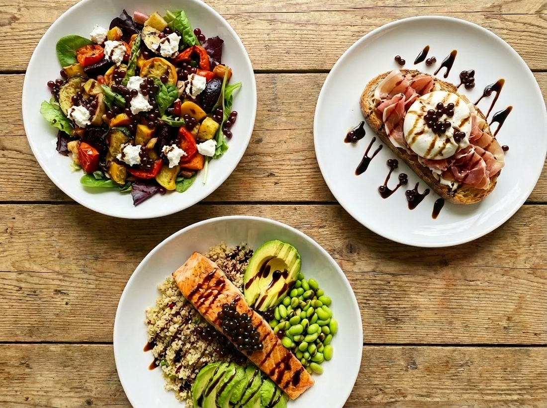 Three gourmet dishes on white plates are arranged on a rustic wooden table. Each dish is topped with glossy, dark balsamic pearls that look natural and appetising. 