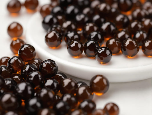Close-up of glossy black balsamic pearls with smooth spherical surfaces, showcasing their molecular gastronomy appeal as gourmet garnish
