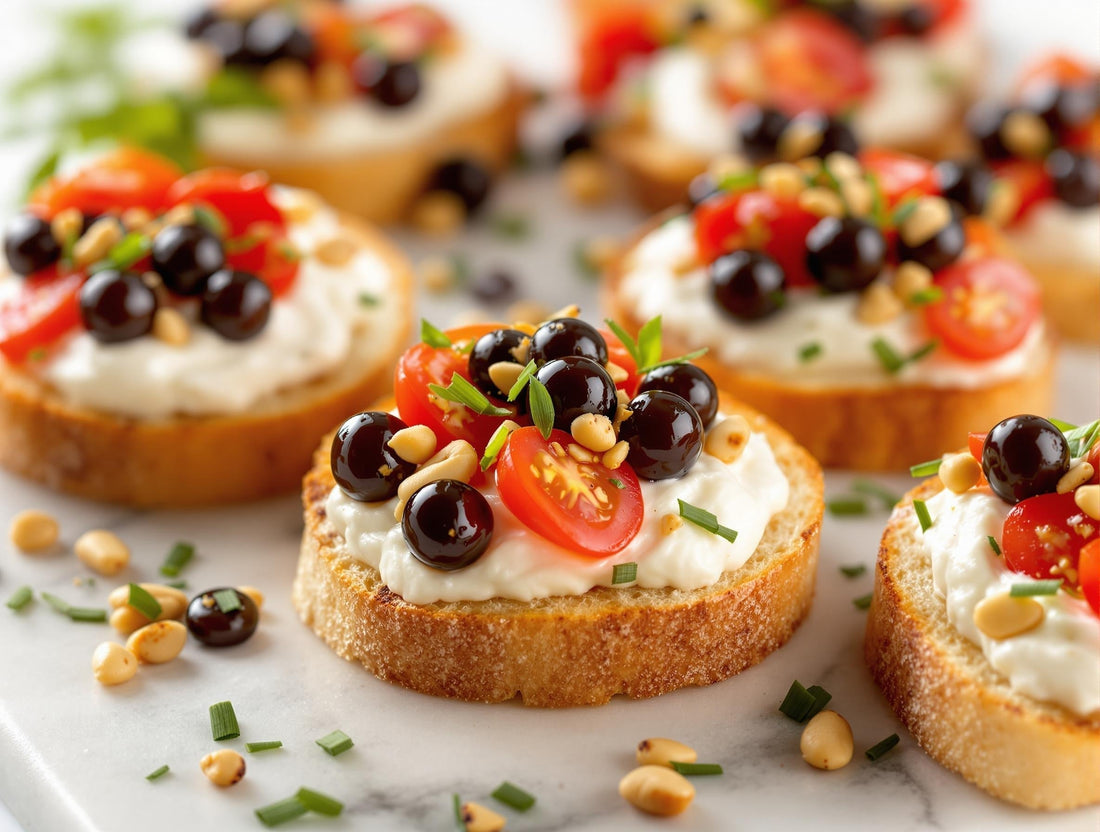 Elegant whipped ricotta crostini topped with cherry tomatoes, pine nuts, and Sticky Balsamic Lemon Pearls on a marble serving board