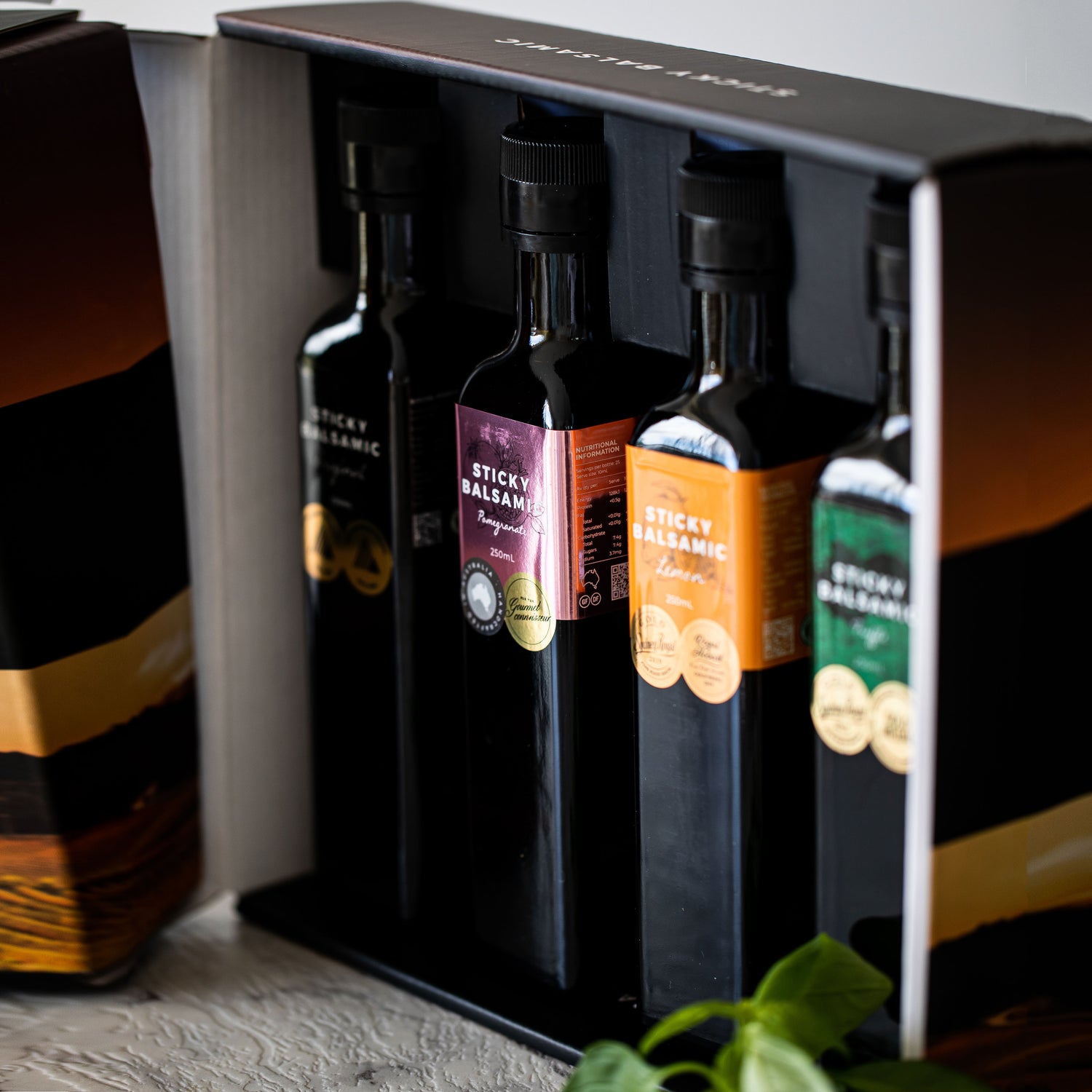Sticky balsamic bottles gift box with dark glass bottles in open holder