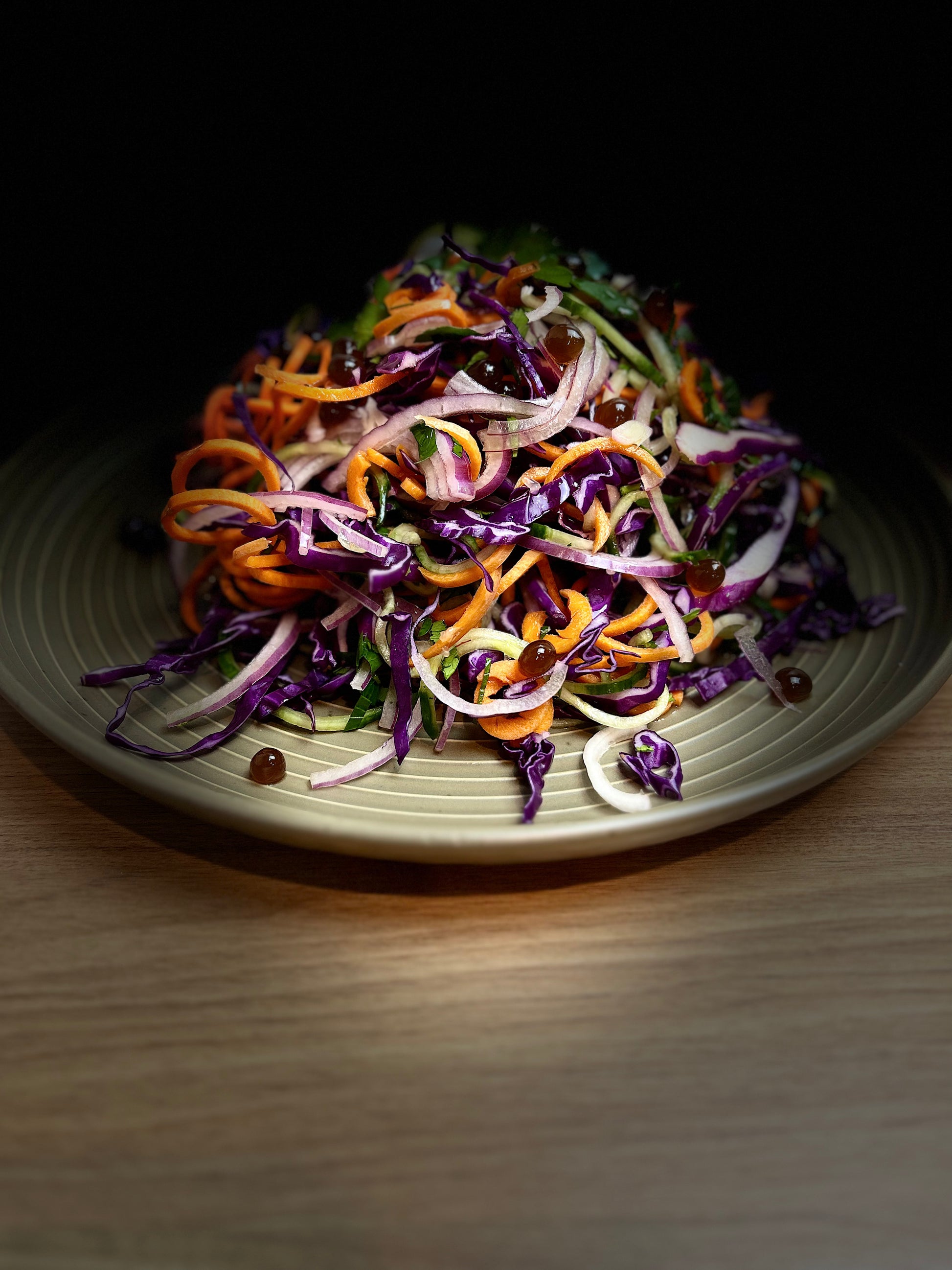 Seasonal Winter Salad with Sticky Balsamic Pearls containing carrot, lettuce, red onion, cabbage and other winter vegetables.