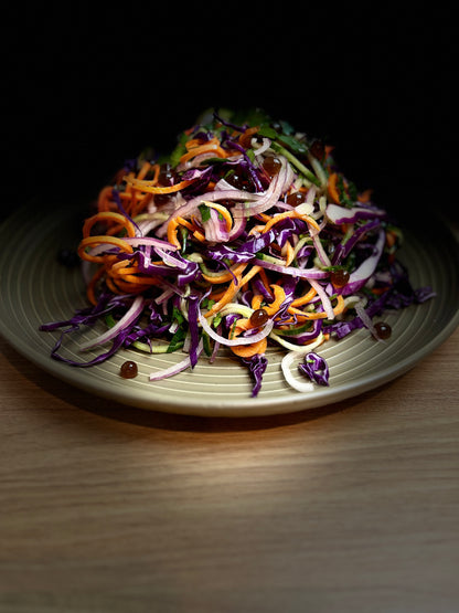 Seasonal Winter Salad with Sticky Balsamic Pearls containing carrot, lettuce, red onion, cabbage and other winter vegetables.