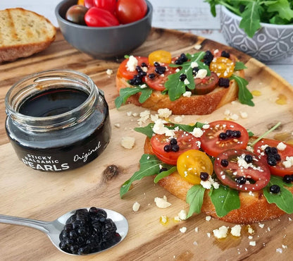 Balsamic pearls on crostini with tomatoes, arugula, and crumbled cheese