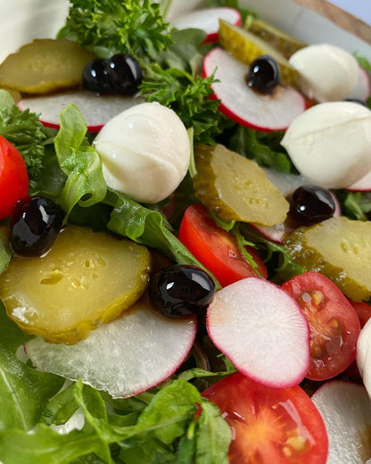 Sticky Balsamic Pearls on a salad of lettuce, radish, pickle, tomato and buffalo mozzarella