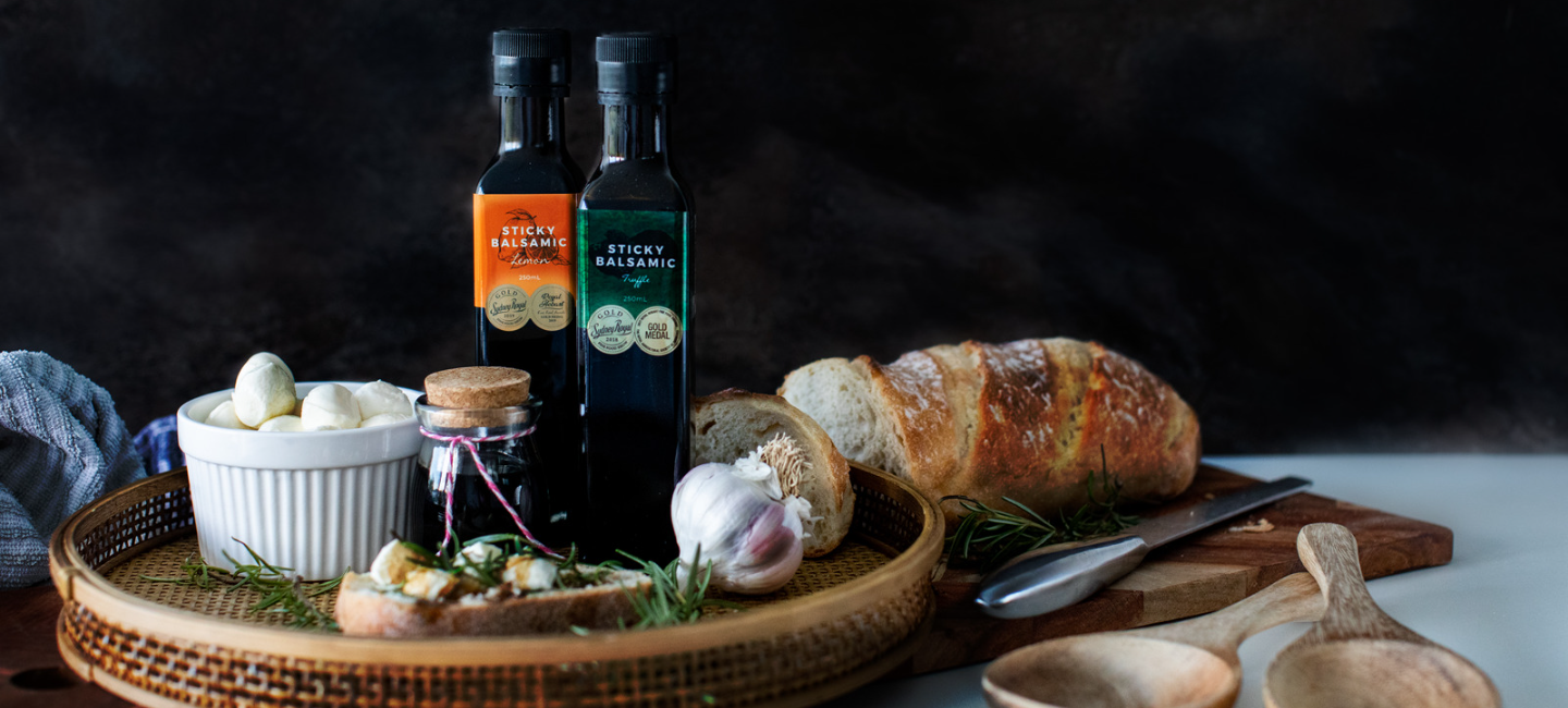Sticky Balsamic Truffle and Lemon on a wicker board with cheese and bread, beautifully presented on a bread board with a bread knife.