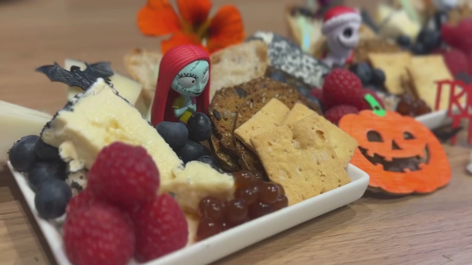 Load video: Halloween image showing spooky elements, sticky balsamic pearls, fruit, cheese, meats, crackers.