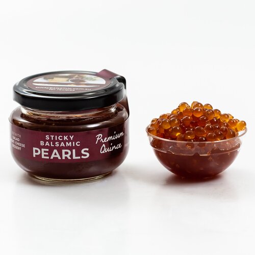 Premium quince pearls sticky balsamic jar beside a bowl of amber pearls