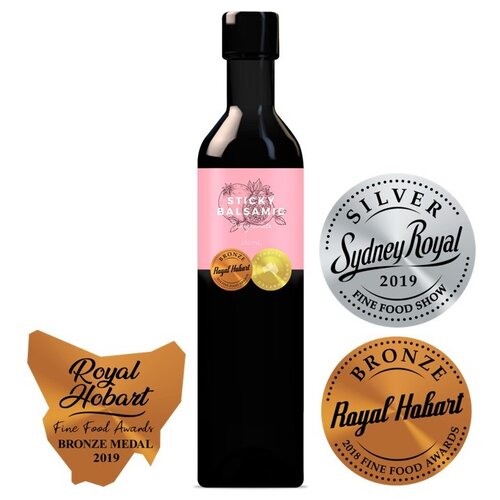 Sticky balsamic bottle with award badges beside it